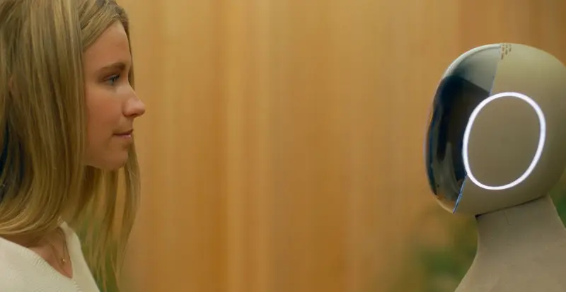 A girl and 1X humanoid robot NEO standing face to face