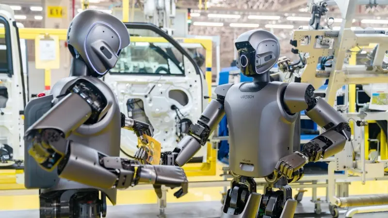 Two UBTECH humanoids at a car factory
