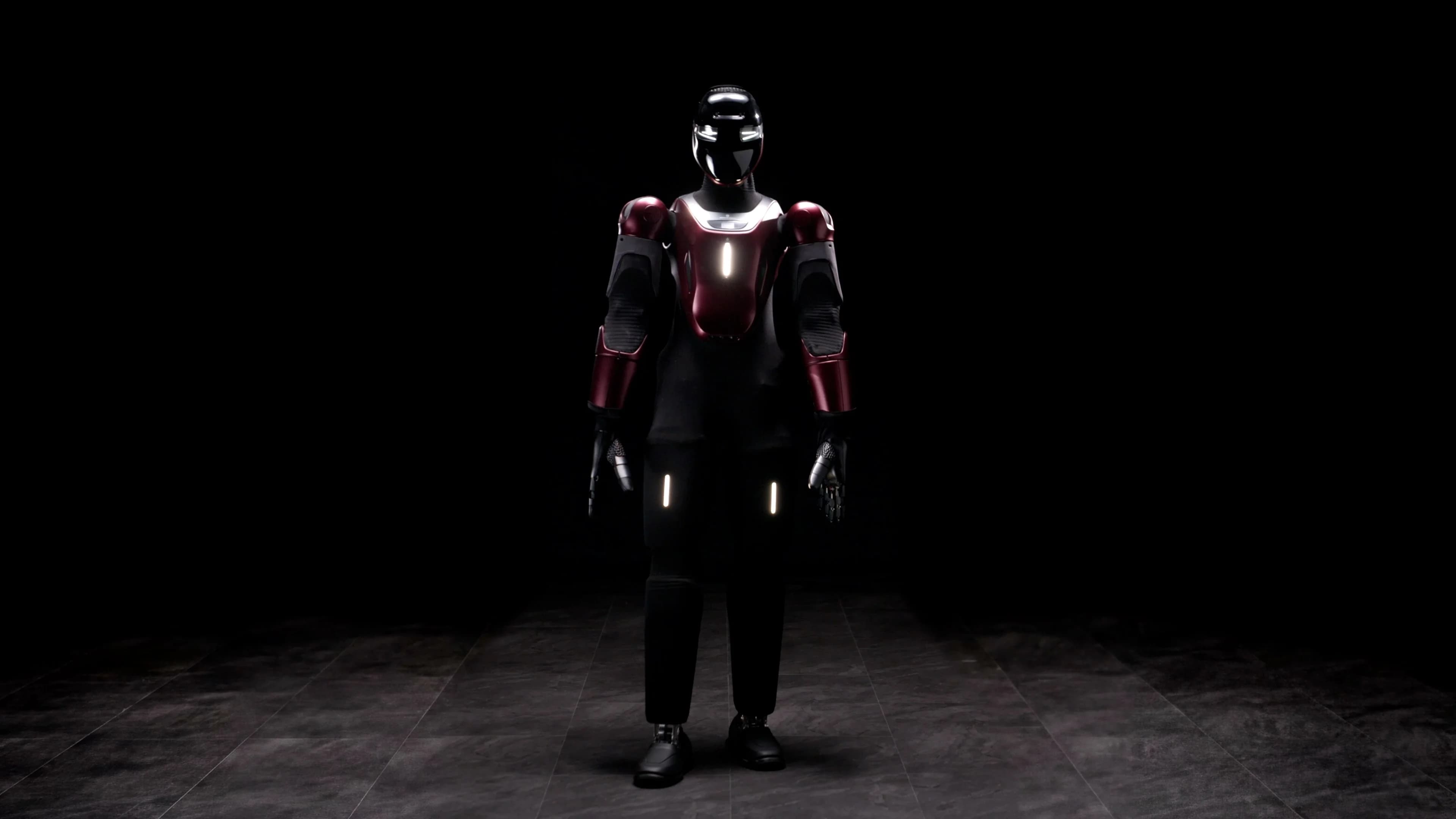 A full-body view of the GENE.01 humanoid robot standing in a sparsely lit room. It features a sleek black and burgundy outer shell, a glossy black visor with illuminated white eyes, and glowing indicator lights on its chest and thighs.