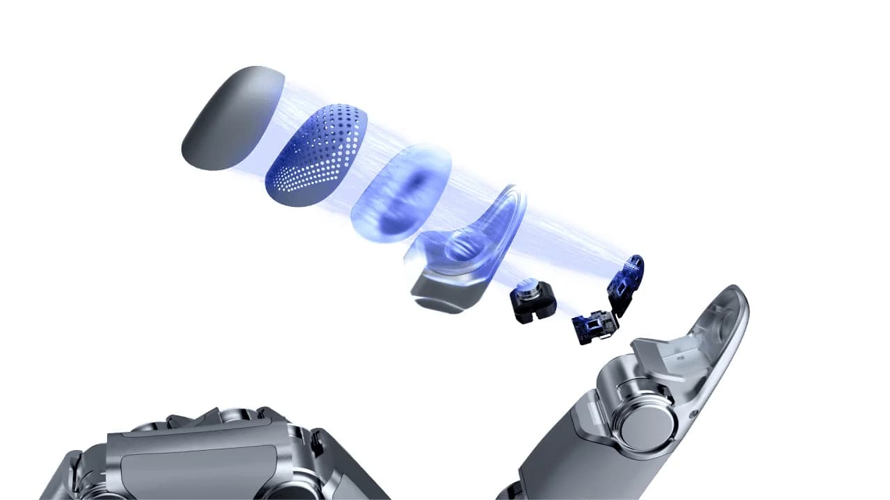 An exploded diagram of a robotic fingertip, showing the internal layers including the outer skin, tactile grid, lens, and camera sensor.